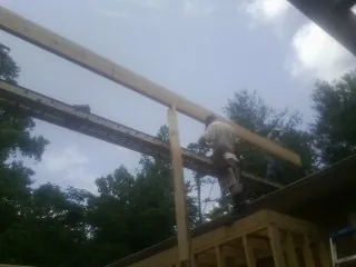 Carpenter setting a ridge beam over a new addition frame — Ice Dam Removal by Roofing Brothers in Paint Lick