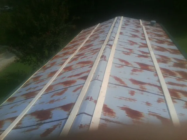 Rusted metal roof panels with new wood purlins before replacement — Storm Damage Roof Repair in Paint Lick by Roofing Brothers