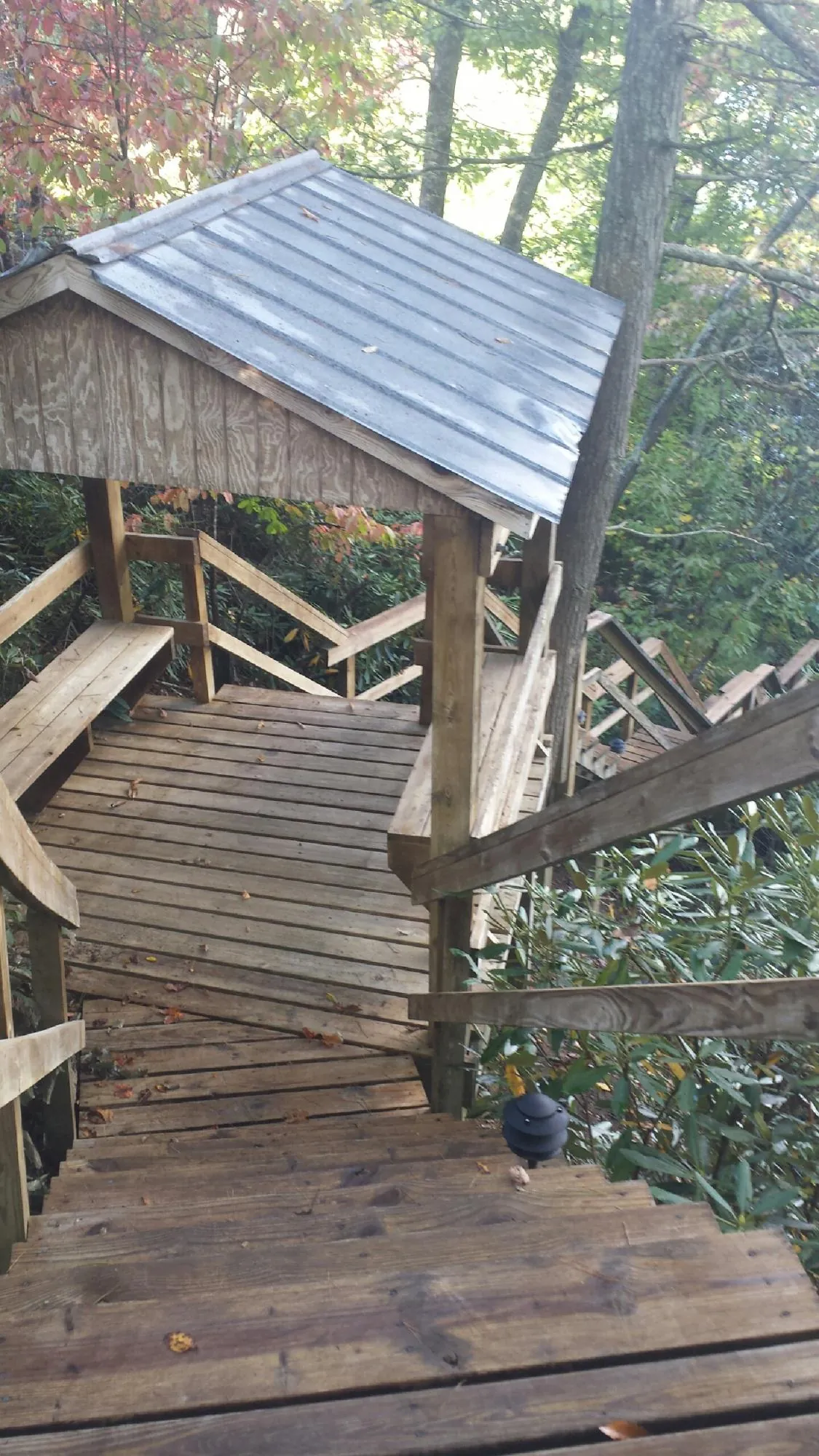Metal roofed shelter over wooden steps on a wooded walkway — Skylight Repair & Installation work by our crew in Paint Lick