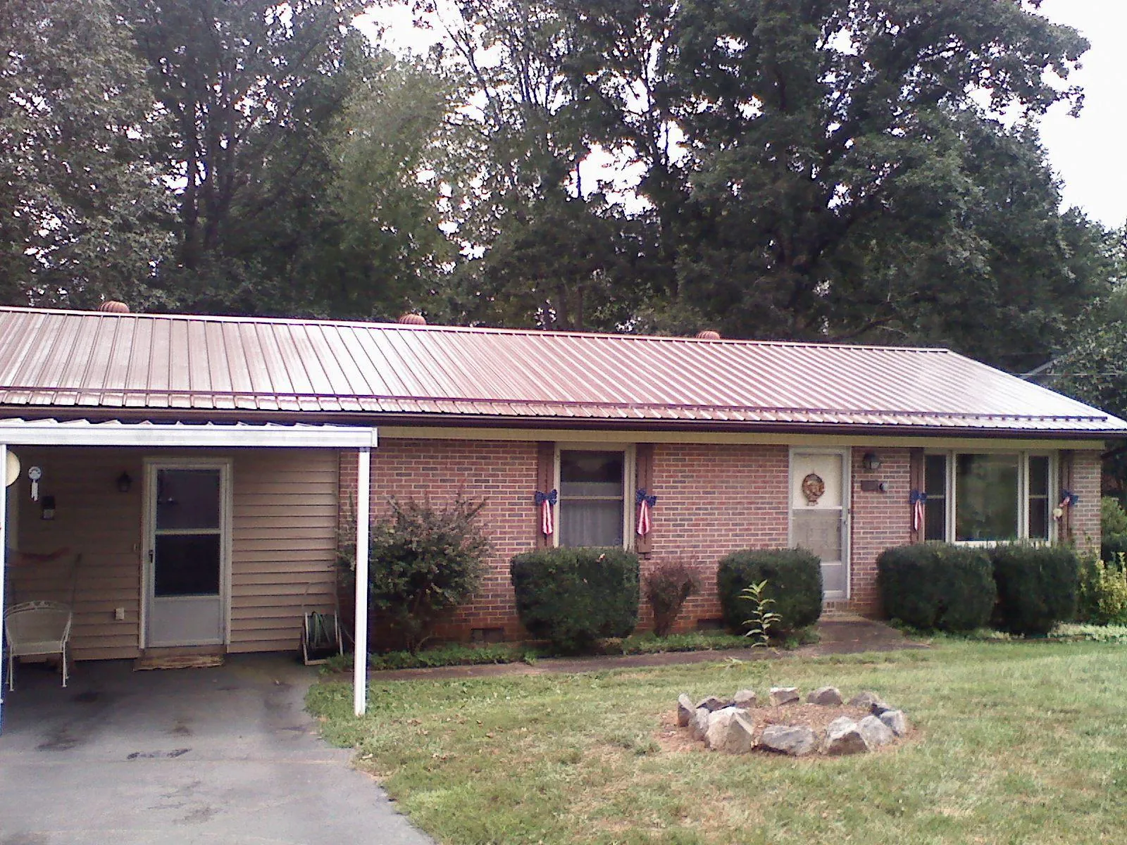 Bronze metal roof and carport on a brick ranch home — Roof Repair work by our crew in Paint Lick