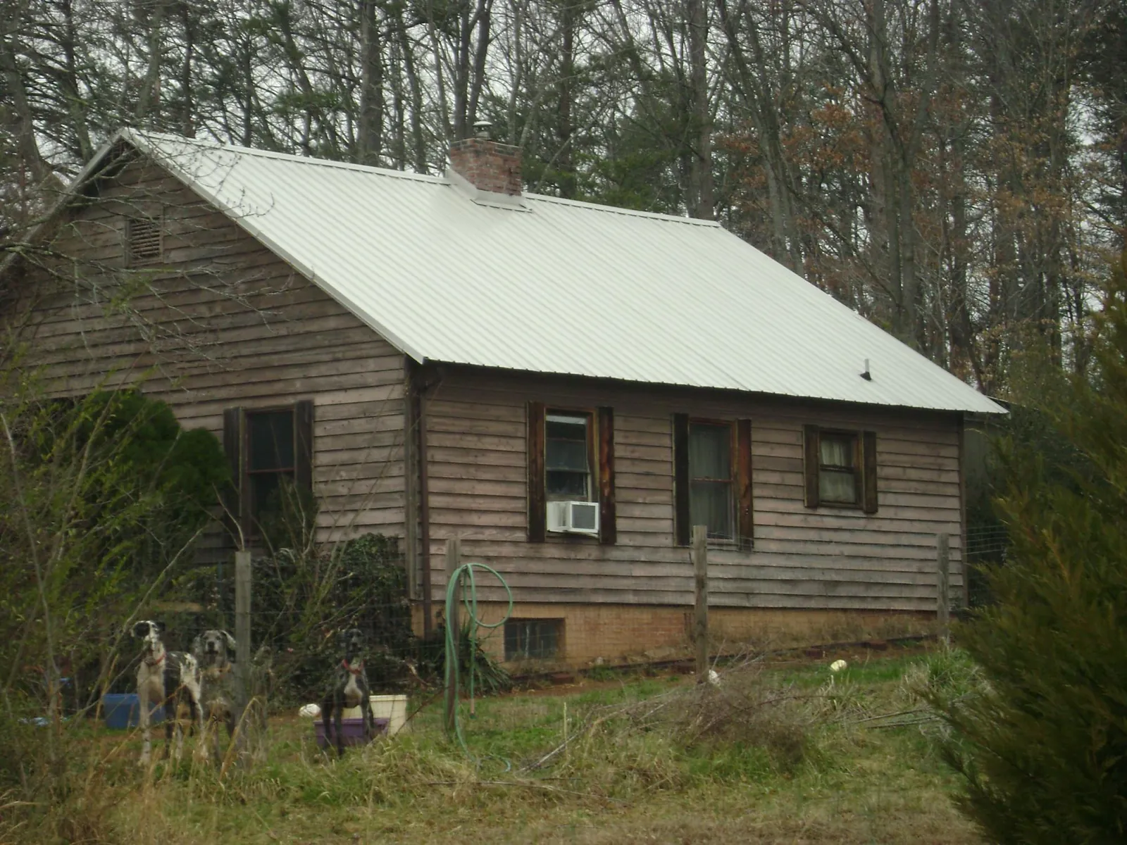 White metal roof on an old wood sided farmhouse, from a Metal Roof Installation job in Paint Lick